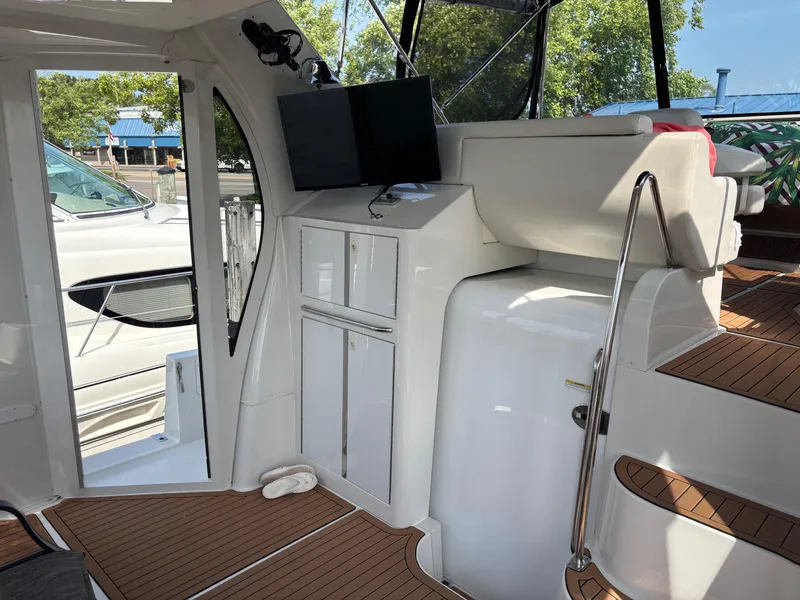 Slide: The Image of 2003 Carver 444 Cockpit Motor Yacht interior with seating, cabinets, and mounted screen. - 31