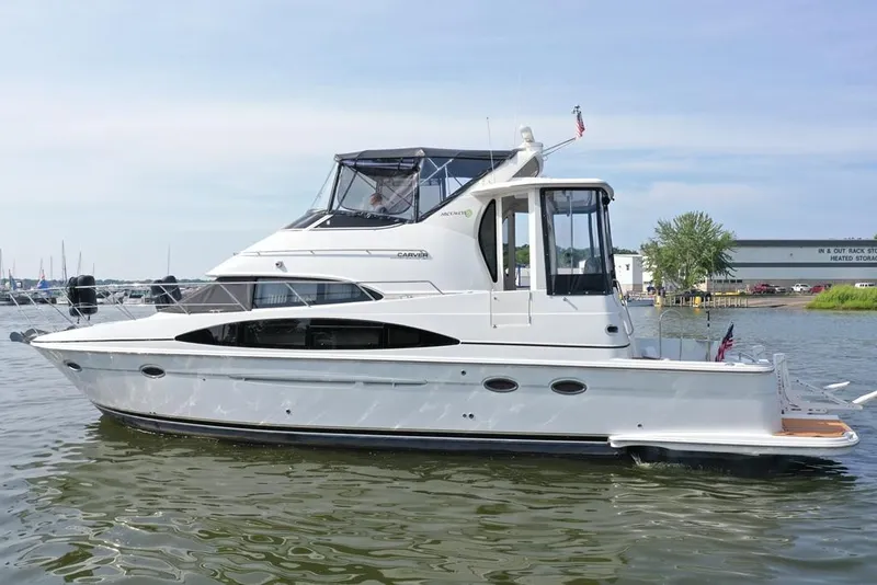 Slide: The Image of 2003 Carver 444 Cockpit Motor Yacht on calm water, side view. - 5