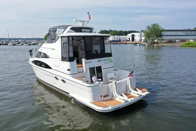 Slide: The Image of 2003 Carver 444 Cockpit Motor Yacht on calm water near marina. - 6