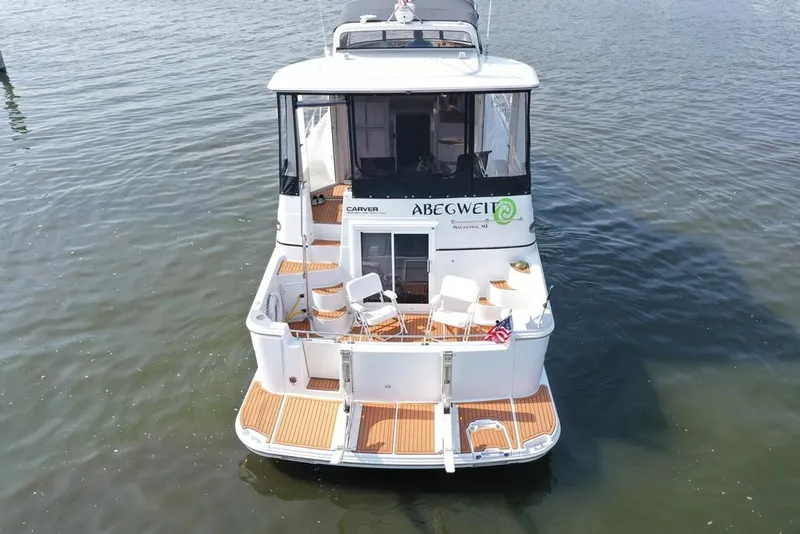 Slide: The Image of 2003 Carver 444 Cockpit Motor Yacht on water, rear view with seating area. - 7