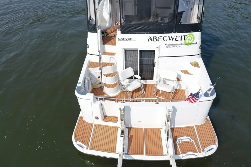 Slide: The Image of 2003 Carver 444 Cockpit Motor Yacht with seating, docked on calm water. - 8