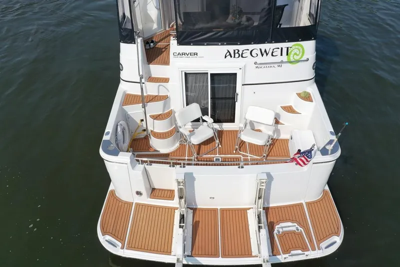 Slide: The Image of 2003 Carver 444 Cockpit Motor Yacht with seating, American flag, and teak deck. - 9