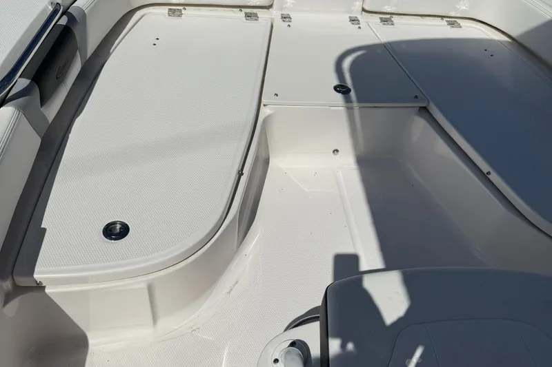 Slide: The Image of 2025 Robalo 206 Cayman boat interior with white seating and storage compartments. - 10