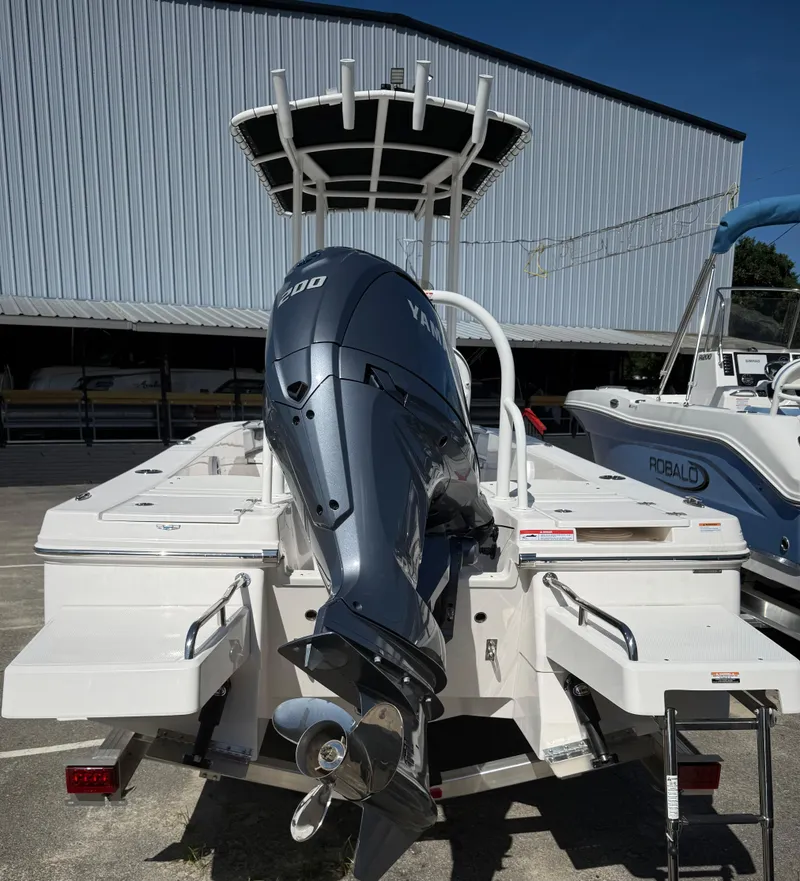 Slide: The Image of 2025 Robalo 206 Cayman boat with Yamaha engine, docked outdoors. - 2