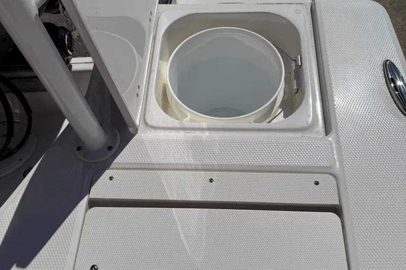 Slide: The Image of 2025 Robalo 206 Cayman boat storage compartment with open hatch and white bucket. - 9