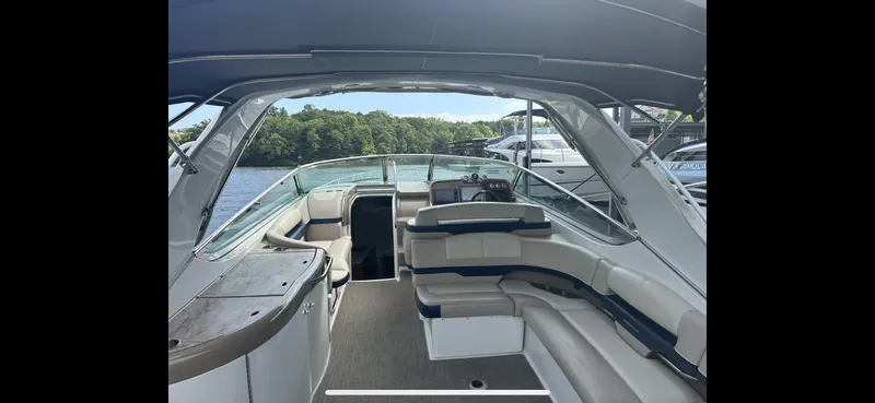 Slide: The Image of 2018 Formula 370 Super Sport boat interior with seating and helm, docked by a lake. - 28