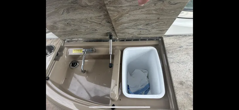 Slide: The Image of 2018 Formula 370 Super Sport boat sink and storage compartment with open lid. - 29