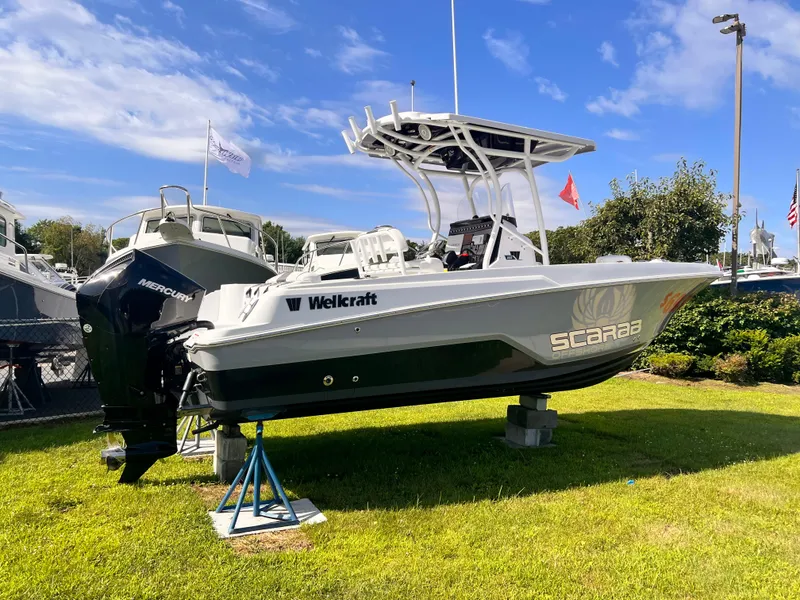 Slide: The Image of 2023 Wellcraft 222 Fisherman boat displayed outdoors on grass. - 3