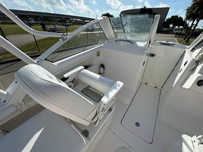 Slide: The Image of 2013 Everglades 230 Dual Console boat interior with white seating and open deck area. - 12