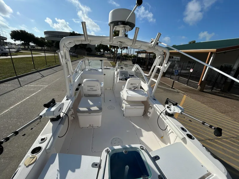 Slide: The Image of 2013 Everglades 230 Dual Console boat with fishing gear, docked under a clear sky. - 17