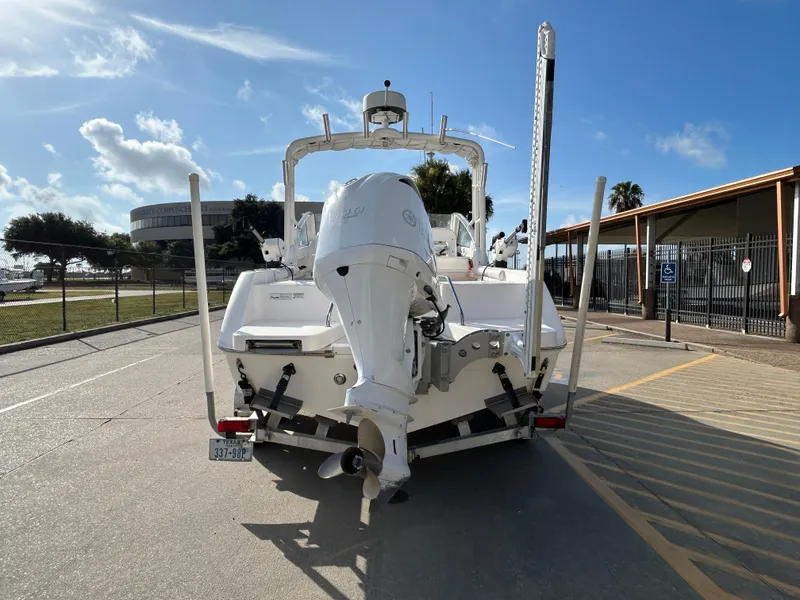 Slide: The Image of 2013 Everglades 230 Dual Console boat on trailer, parked outdoors under clear sky. - 6
