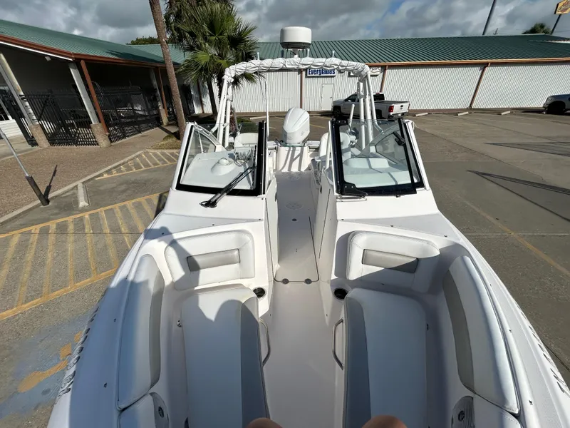 Slide: The Image of 2013 Everglades 230 Dual Console boat in a parking lot, showcasing seating and console. - 8