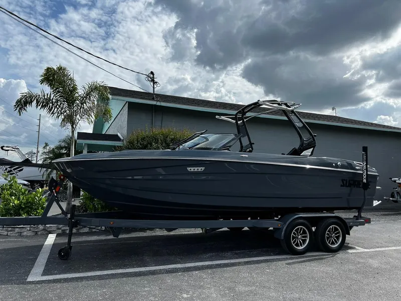 The Image of 2024 Supreme S220 boat on trailer under cloudy sky. - 1