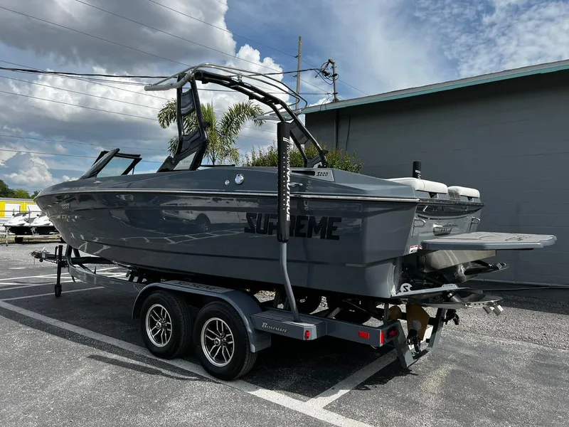 Slide: The Image of 2024 Supreme S220 boat on trailer, parked outdoors under cloudy sky. - 4