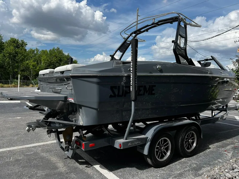 Slide: The Image of 2024 Supreme S220 boat on trailer under cloudy sky. - 5