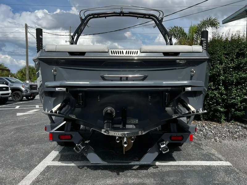 Slide: The Image of 2024 Supreme S220 boat rear view in parking lot, showcasing sleek design and features. - 6