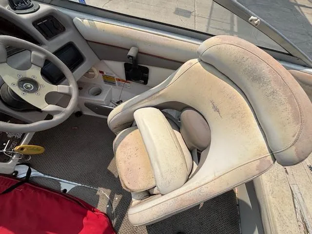 Slide: The Image of 2002 Four Winns 190 Horizon boat interior with steering wheel and worn seat. - 10