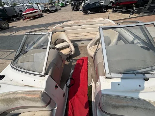 Slide: The Image of 2002 Four Winns 190 Horizon boat interior with dual windshields and seating, parked outdoors. - 19