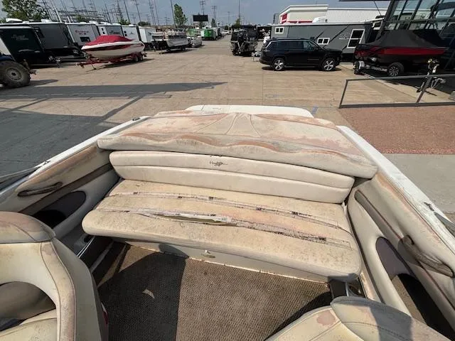 Slide: The Image of 2002 Four Winns 190 Horizon boat interior with worn seating in a marina setting. - 21