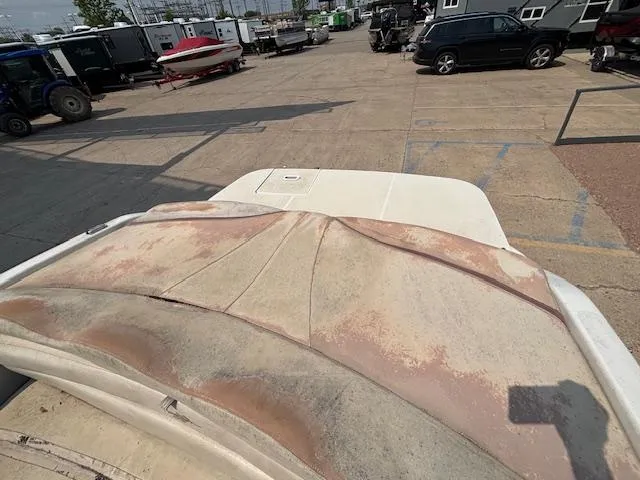 Slide: The Image of 2002 Four Winns 190 Horizon boat with worn upholstery in a parking lot. - 24