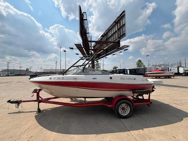Slide: The Image of 2002 Four Winns 190 Horizon boat on trailer under a cloudy sky. - 25
