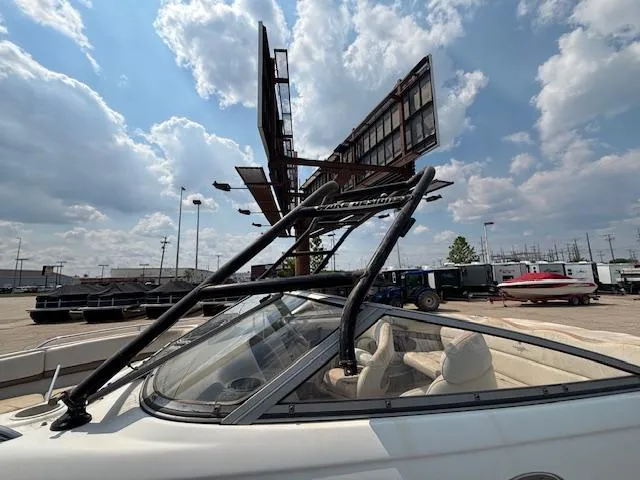 Slide: The Image of 2002 Four Winns 190 Horizon boat parked near a large billboard under a cloudy sky. - 26