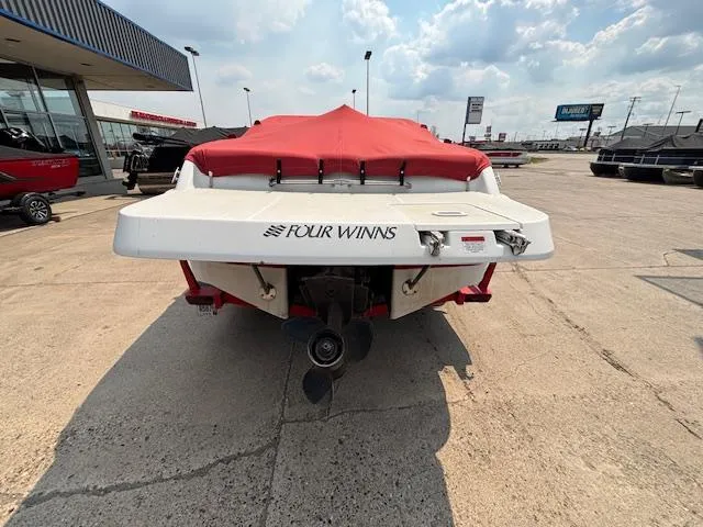 Slide: The Image of 2002 Four Winns 190 Horizon boat with red cover, rear view in a dealership lot. - 4