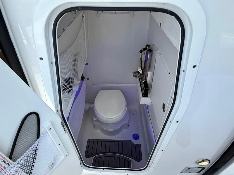 Slide: The Image of 2023 Sea Hunt Gamefish 27 boat interior with compact marine toilet and storage. - 14