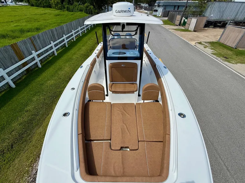 Slide: The Image of 2023 Sea Hunt Gamefish 27 boat with forward seating, featuring brown cushions and Garmin equipment. - 17