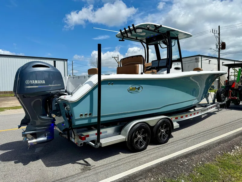 Slide: The Image of 2023 Sea Hunt Gamefish 27 boat with Yamaha engine on trailer, parked outdoors. - 4