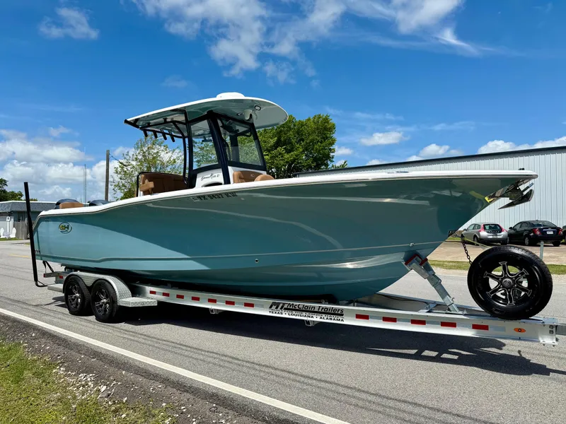 Slide: The Image of 2023 Sea Hunt Gamefish 27 Forward Seating boat on trailer, under clear blue sky. - 5