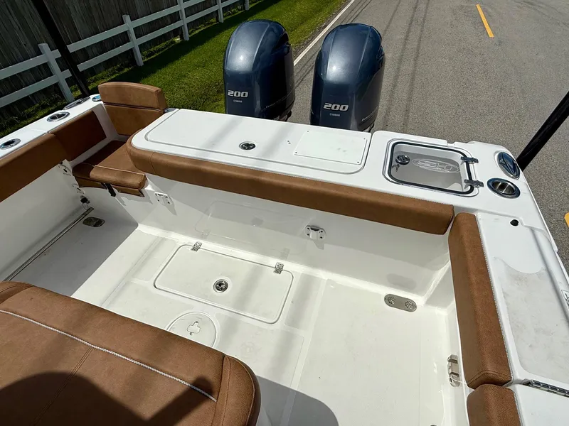 Slide: The Image of 2023 Sea Hunt Gamefish 27 boat interior with brown seating and twin 200 engines. - 8