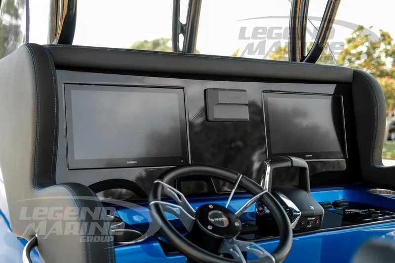Slide: The Image of 2023 Statement 350 Open boat dashboard with dual Garmin displays and steering wheel. - 12
