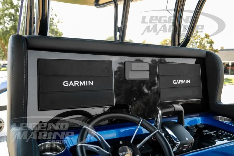 Slide: The Image of 2023 Statement 350 Open boat dashboard with dual Garmin displays and steering wheel. - 16