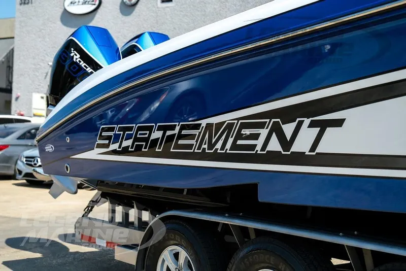 Slide: The Image of 2023 Statement 350 Open boat with blue and white design on a trailer. - 51