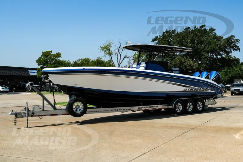 Slide: The Image of 2023 Statement 350 Open boat on trailer, parked outdoors, featuring sleek design and triple engines. - 7