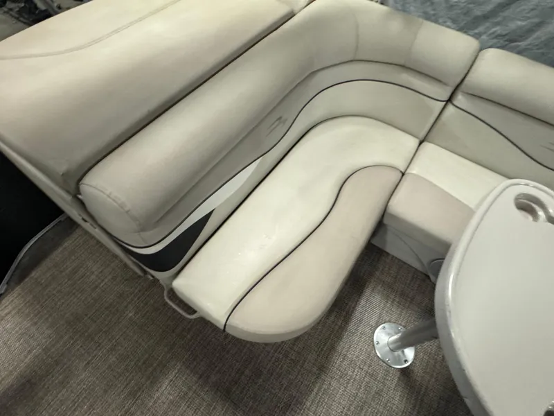 Slide: The Image of 2019 Bennington S21 boat interior with beige seating and table. - 18