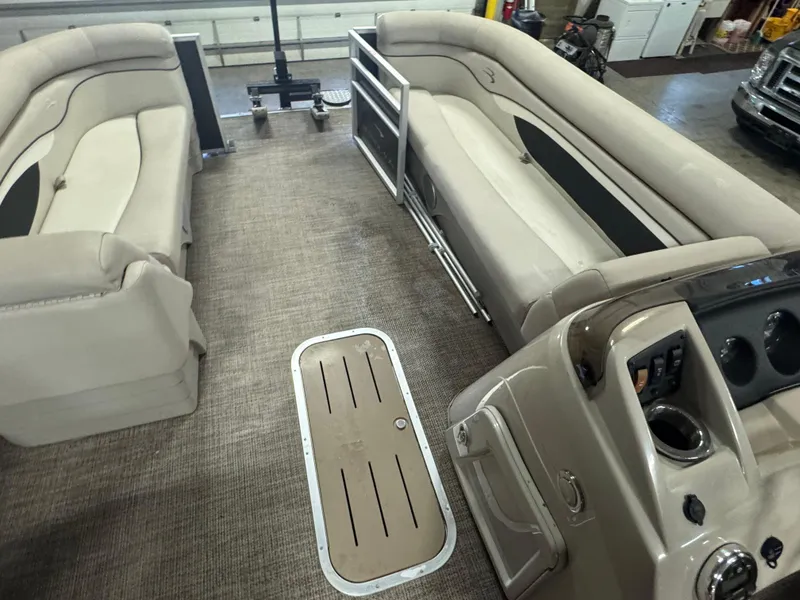 Slide: The Image of Interior of a 2019 Bennington S21 pontoon boat with beige seating and control panel. - 21