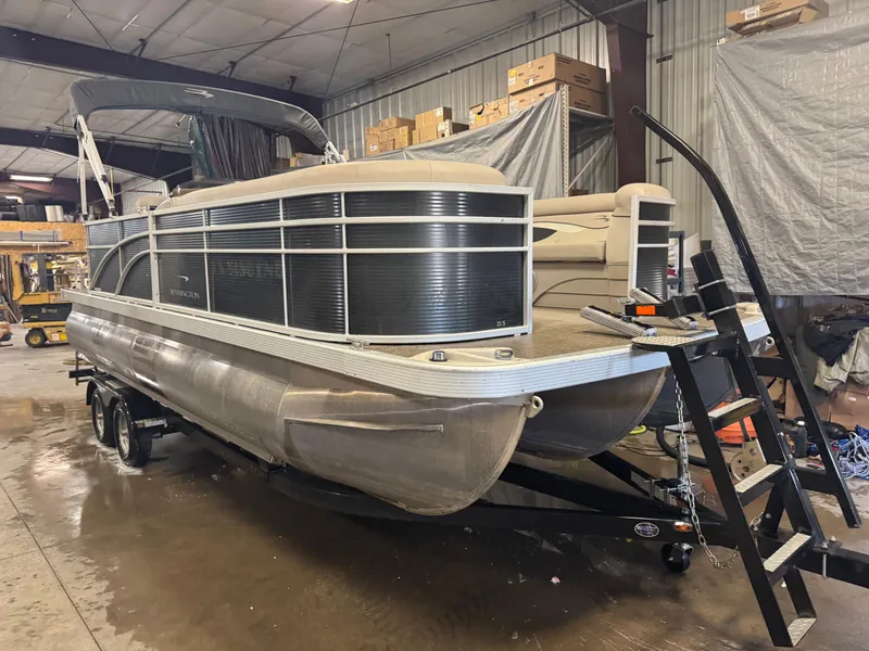 Slide: The Image of 2019 Bennington S21 pontoon boat in a warehouse, on a trailer with a ladder. - 3