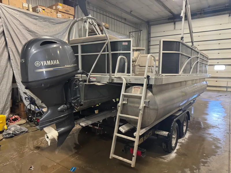 Slide: The Image of 2019 Bennington S21 pontoon boat with Yamaha outboard motor in a garage setting. - 4