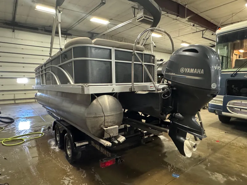 Slide: The Image of 2019 Bennington S21 pontoon boat with Yamaha motor in a garage setting. - 5
