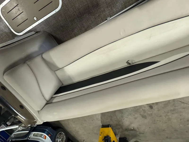 Slide: The Image of 2019 Bennington S21 boat interior with beige seating and carpeted flooring. - 7