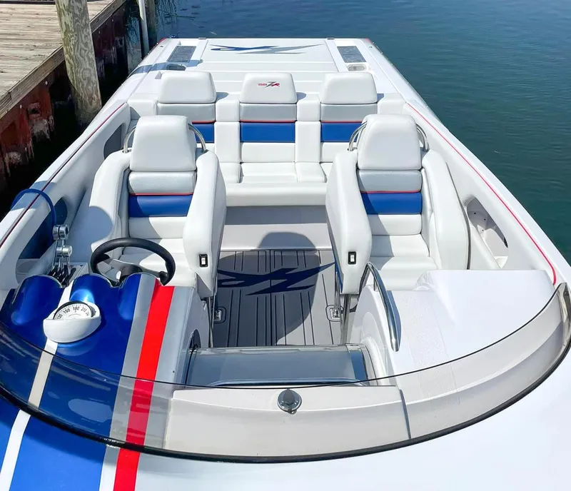 Slide: The Image of 2008 Donzi 38 ZR speedboat interior with white and blue seating, docked by the water. - 11