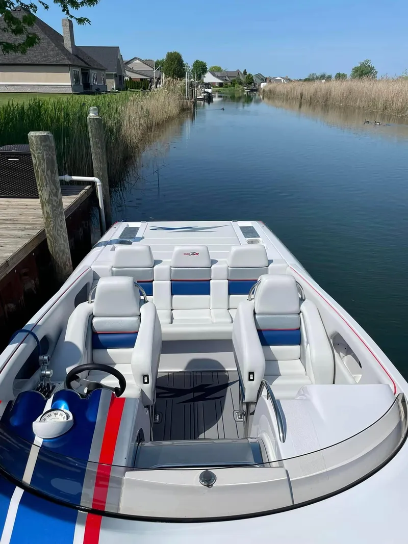 Slide: The Image of 2008 Donzi 38 ZR speedboat docked in a serene canal setting. - 12