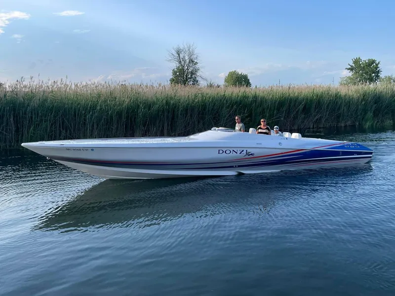 Slide: The Image of 2008 Donzi 38 ZR speedboat cruising on a calm waterway with passengers onboard. - 15