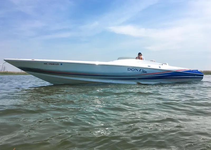 Slide: The Image of 2008 Donzi 38 ZR speedboat on calm water under a clear blue sky. - 3