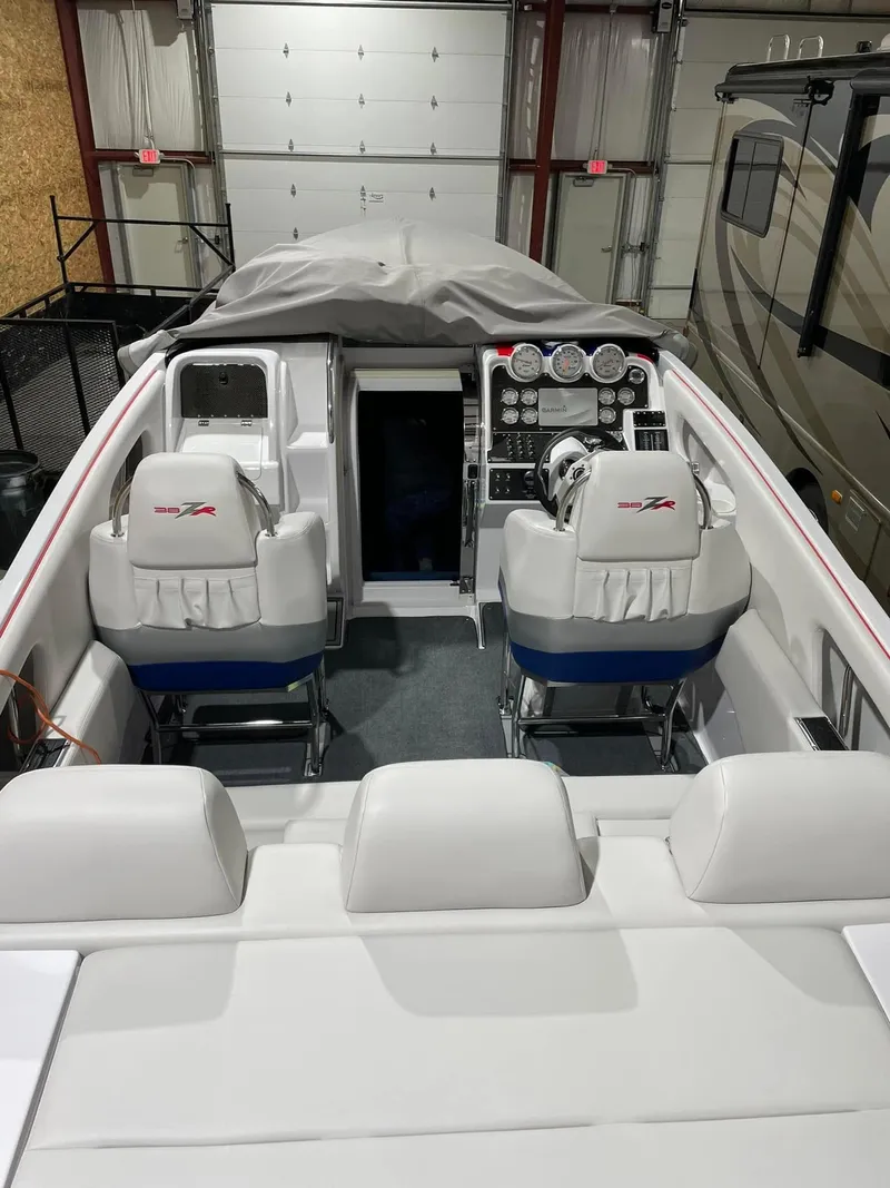 Slide: The Image of 2008 Donzi 38 ZR boat interior with white seating and control panel in a garage. - 8