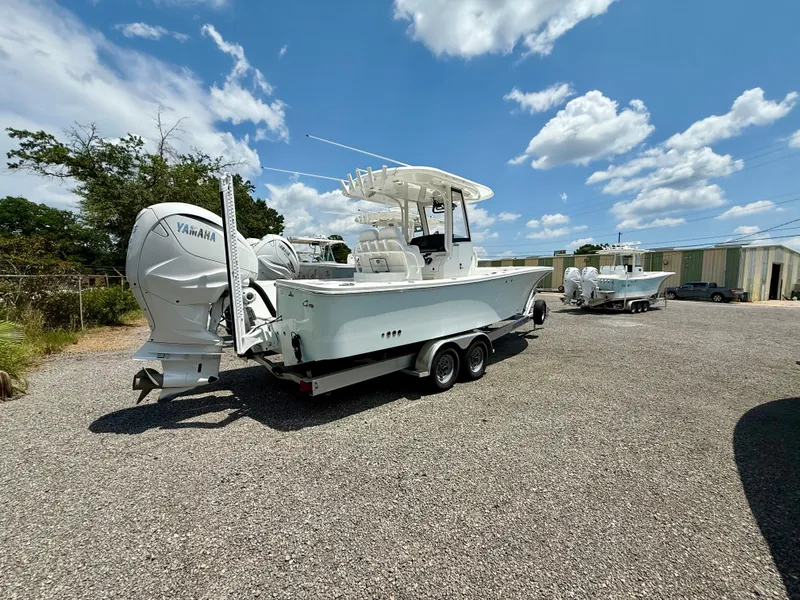 Slide: The Image of 2023 Regulator 26XO boat with Yamaha engines on a trailer, parked outdoors. - 2