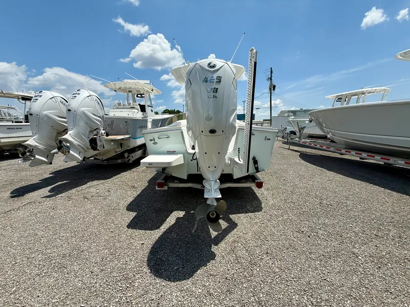 Slide: The Image of 2023 Regulator 26XO boat with Yamaha outboard motor, parked on gravel under blue sky. - 3