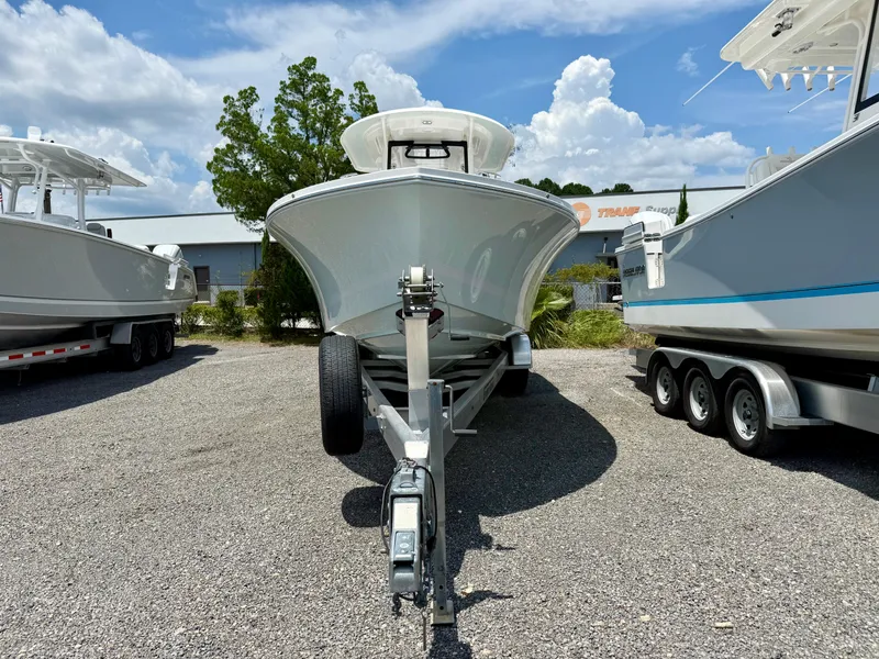 Slide: The Image of 2023 Regulator 26XO boat on trailer, parked outdoors under a blue sky. - 4